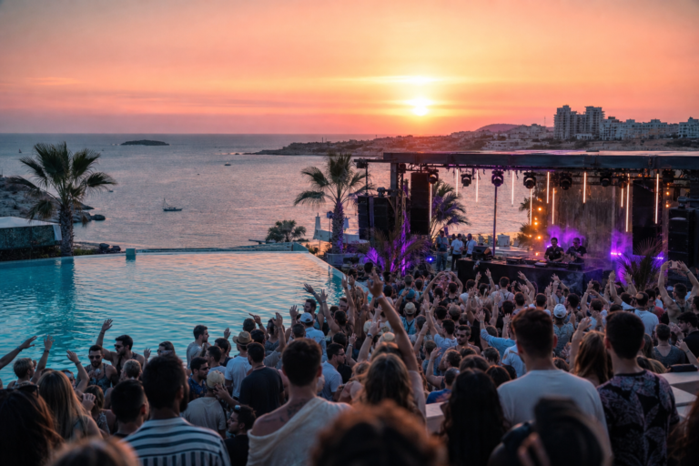 Sunset electronic music pool party at a seaside venue in Malta